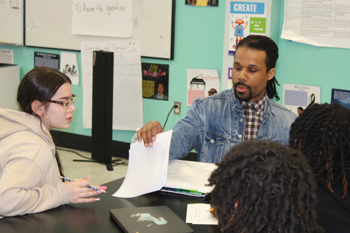 African American teacher working withy students at a table