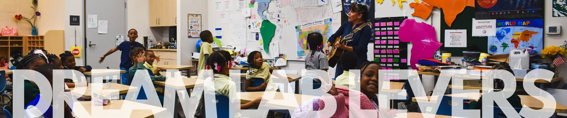 Teacher playing guitar in front of her classroom Teacher playing guitar in front of her classroom
