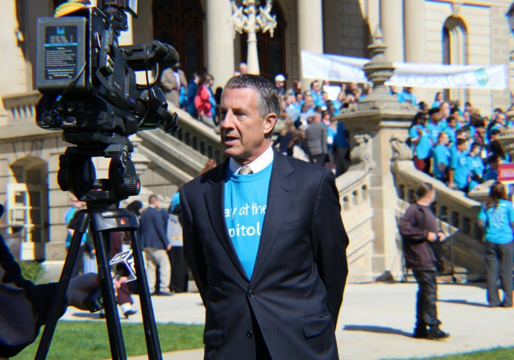 A photo of MAPSA President Dan Quisenberry being interviewed by media during the 2017 Charter Day at the Capitol celebration.