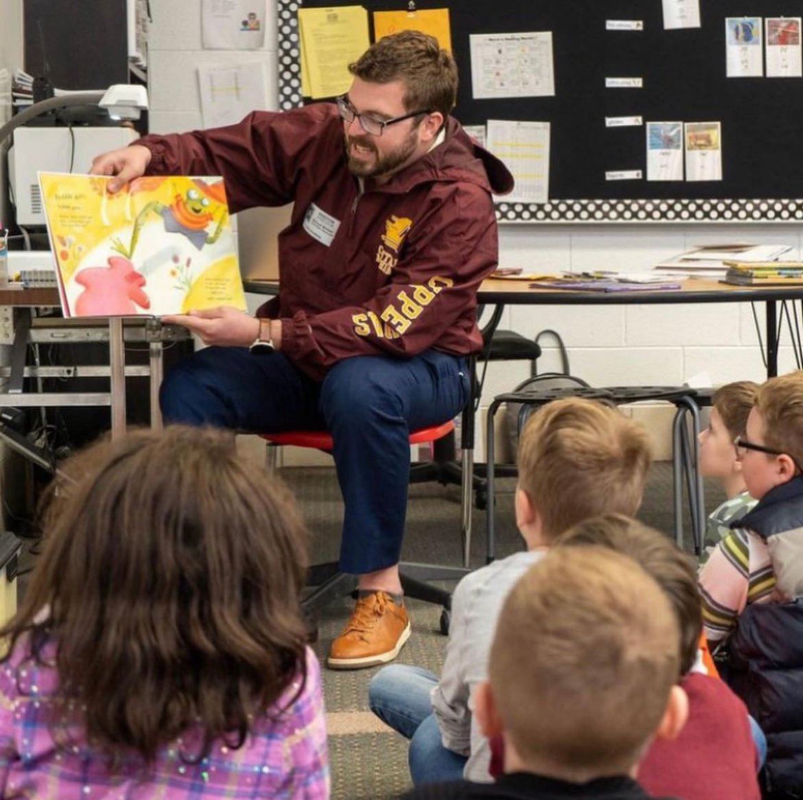 A Central Michigan University Charter School Office employee reads to students. 