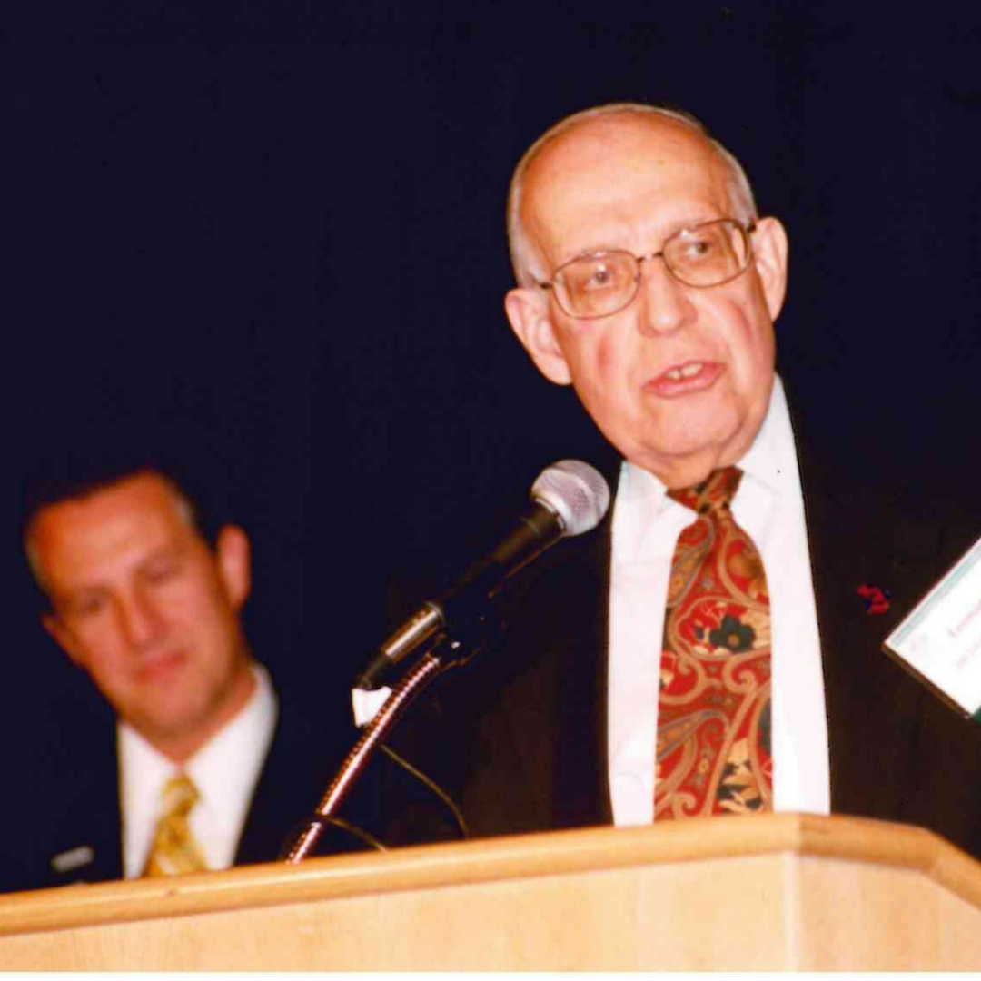 A photo of MAPSA President, Dan Quisenberry, speaking on stage with a male guest.