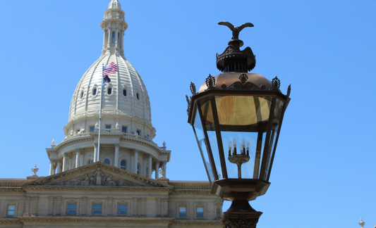 A photo of the Lansing Capitol building and a lantern.