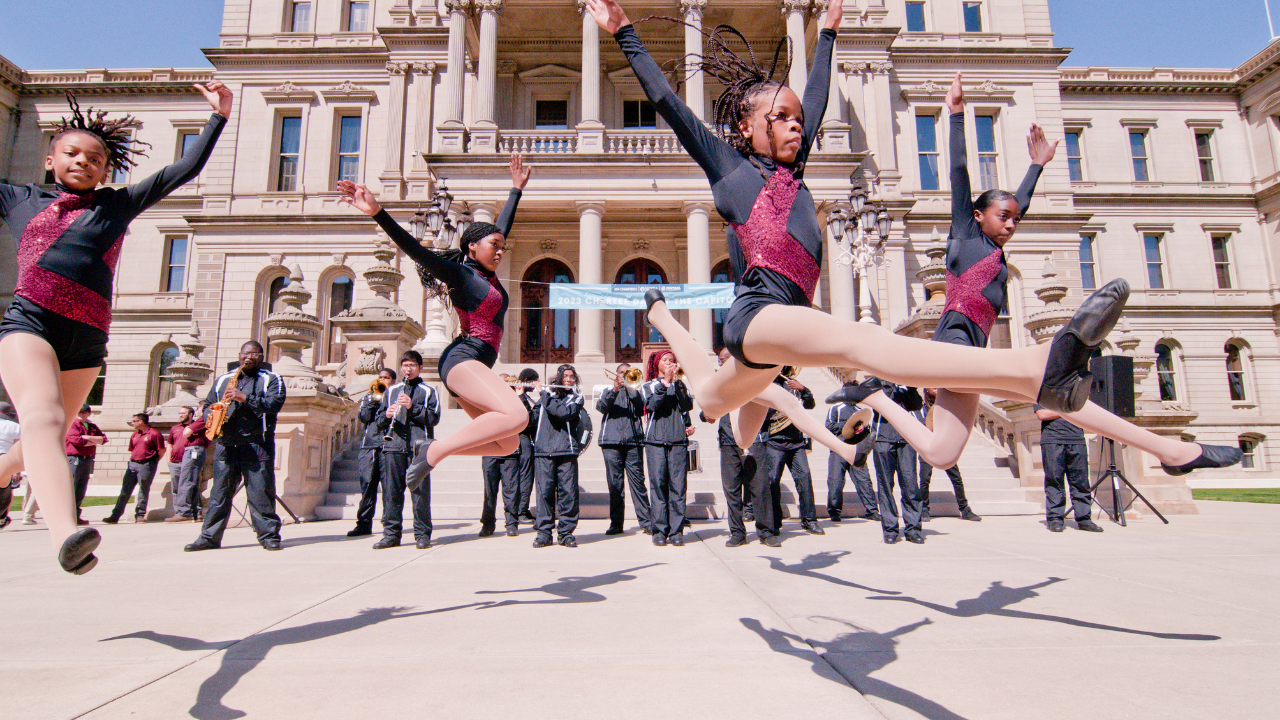 Students performing in front of MI Capitol Steps
