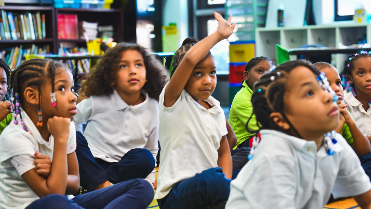 Student raising hand in classroom 