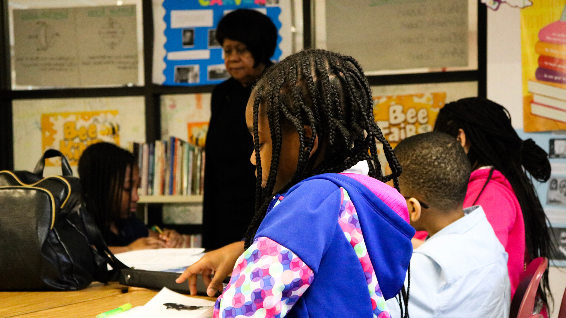 A group of students sit at a table working in class