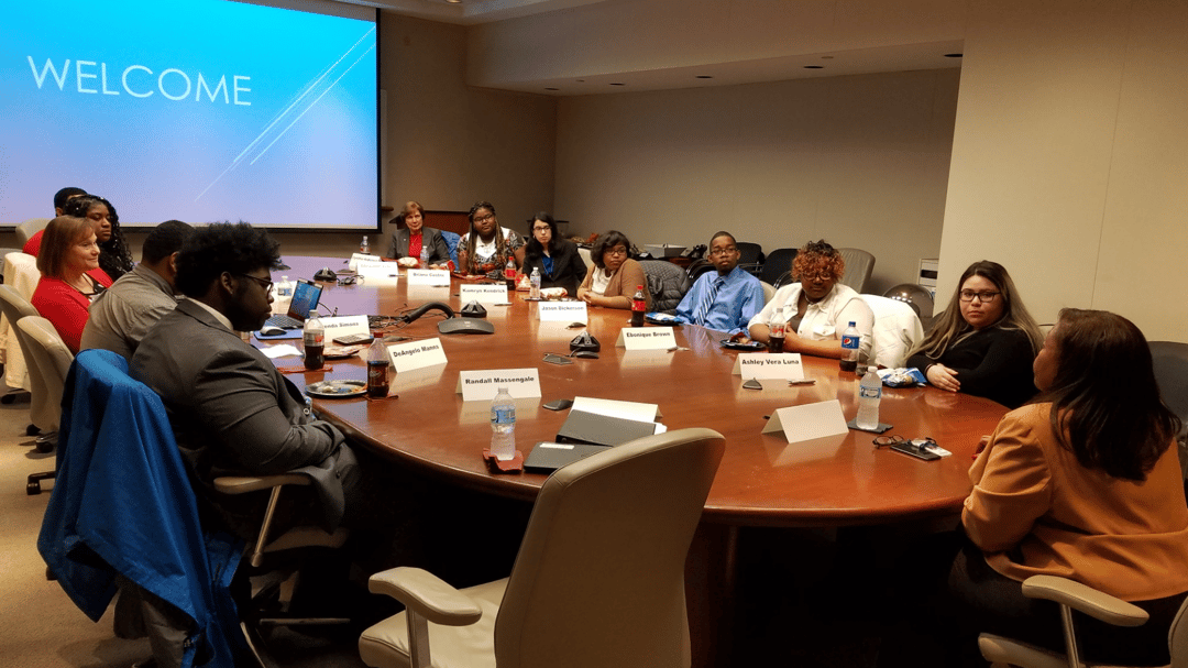 A group of students sits at a large boardroom table with Lisa Cash, the Vice President of Quality and New Product Launch at Ford Motor Company