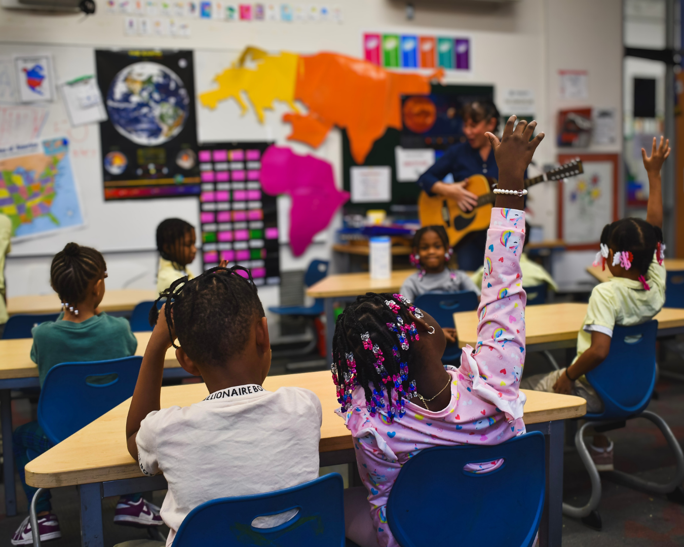 Students raising hands in a classroom